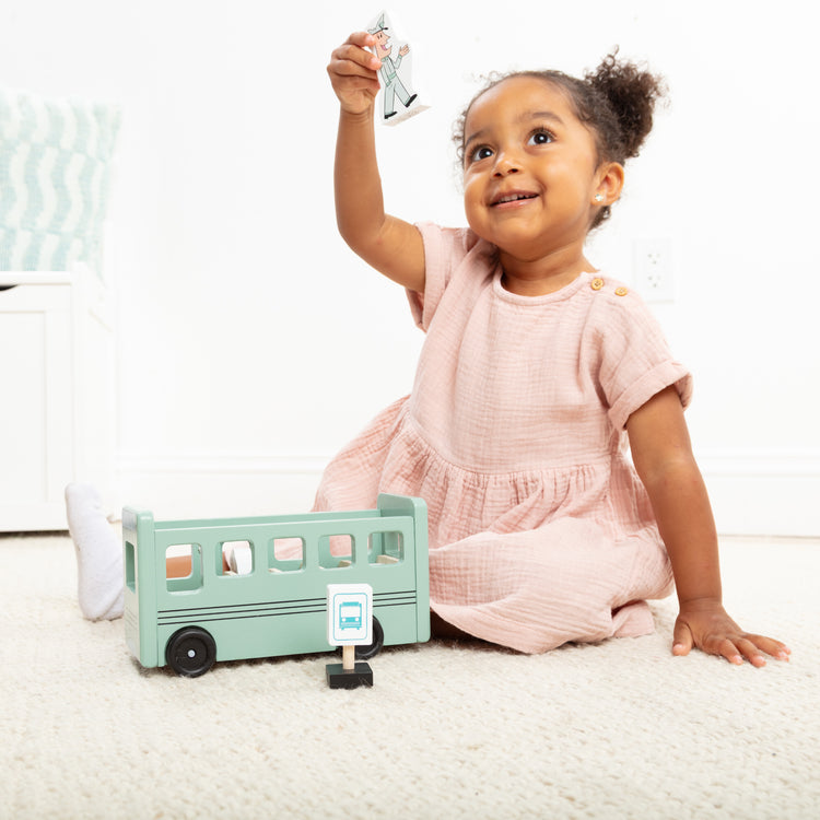 A kid playing with The Melissa & Doug Mo Willems "Don't Let the Pigeon Drive the Bus!" Wooden Play Set - For Ages 3+