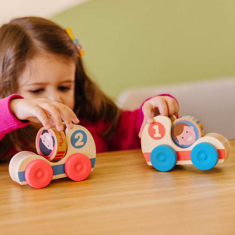A kid playing with The Melissa & Doug GO Tots Wooden Race Cars (2 Cars, 2 Disks)