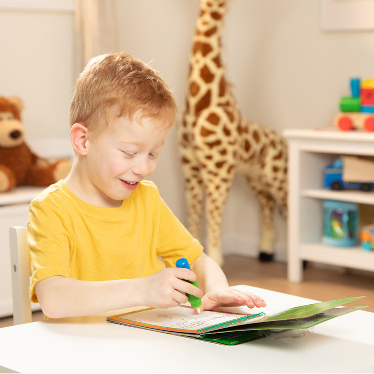 A kid playing with The Melissa & Doug On the Go Water Wow! Reusable Color with Water Activity Pad 3-Pack, Jungle, Safari, Farm