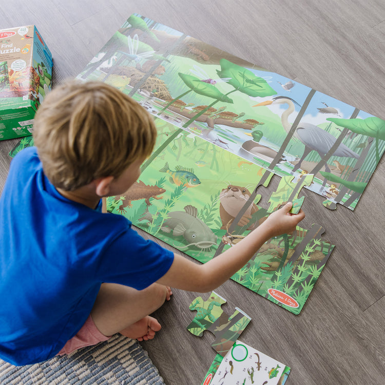 A kid playing with The Melissa & Doug Double-Sided Seek & Find Puzzle