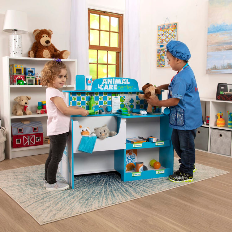 A kid playing with the Melissa & Doug Animal Care Veterinarian and Groomer Wooden Activity Center for Plush Stuffed Pets (Not Included)