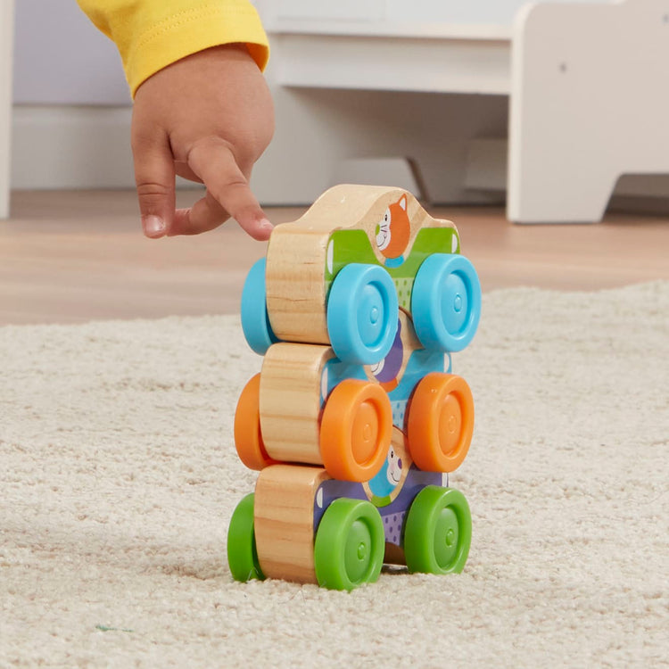 A kid playing with the Melissa & Doug First Play Wooden Animal Stacking Cars (3 pcs)