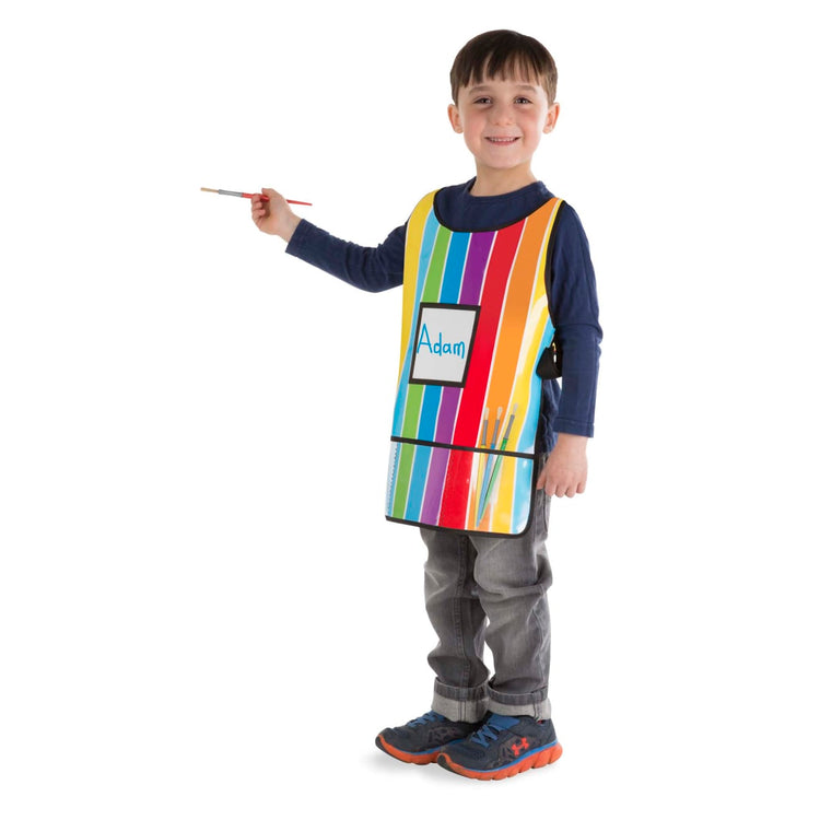 A child on white background with the Melissa & Doug Art Essentials Artist Smock - One Size Fits All