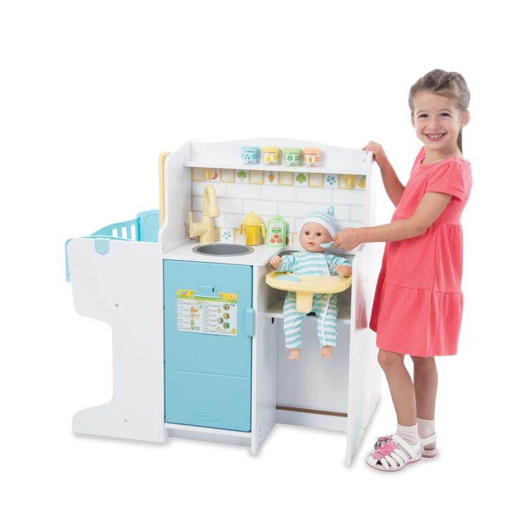 A child on white background with the Melissa & Doug Mine to Love Baby Care Activity Center for Dolls - Kitchen, Nursery, Bathing-Changing