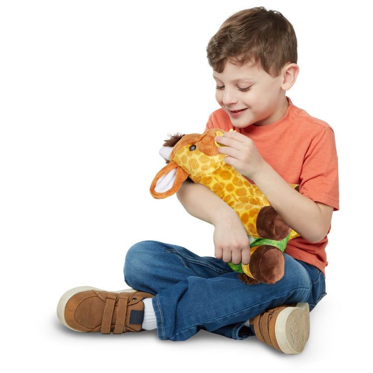 A kid playing with the Melissa & Doug 11-Inch Baby Giraffe Plush Stuffed Animal with Pacifier, Diaper, Baby Bottle