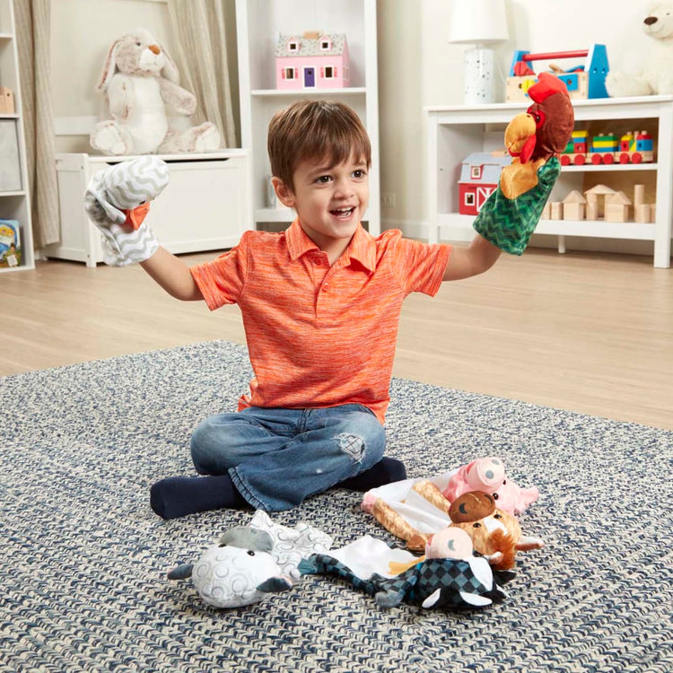 A kid playing with the Melissa & Doug Barn Buddies Hand Puppets, Set of 6 (Cow, Sheep, Horse, Duck, Chicken, Pig)