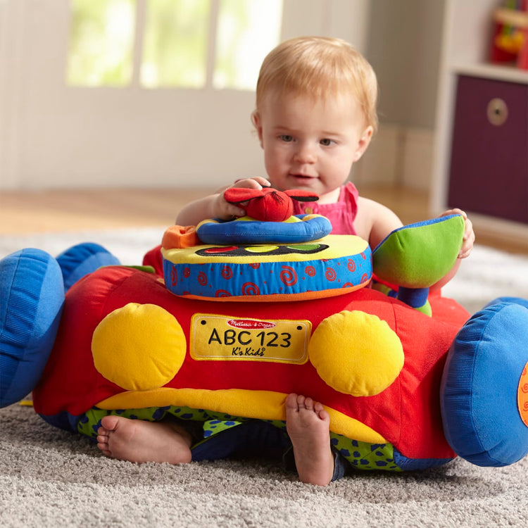 A kid playing with the Melissa & Doug Beep-Beep and Play Activity Center Baby Toy