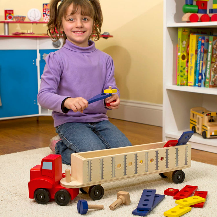 A kid playing with the Melissa & Doug Big Rig Truck Wooden Building Set (22 pcs)