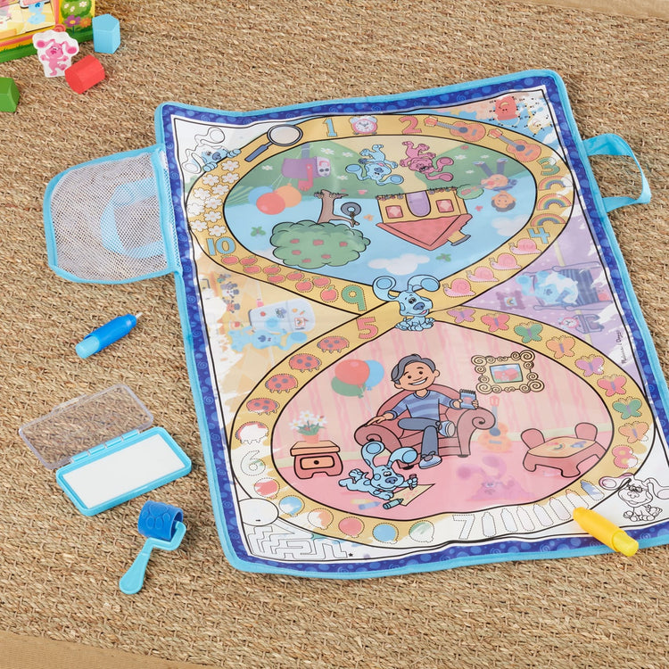 A kid playing with the Melissa & Doug Blue's Clues & You! Water Wow! Activity Mat (20 Inches x 30 Inches) With Reusable Water Reveal Surface