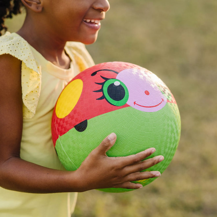 A kid playing with the Melissa & Doug Sunny Patch Bollie Ladybug Classic Rubber Kickball