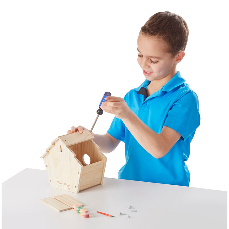 A child on white background with the Melissa & Doug Created by Me! Birdhouse Build-Your-Own Wooden Craft Kit