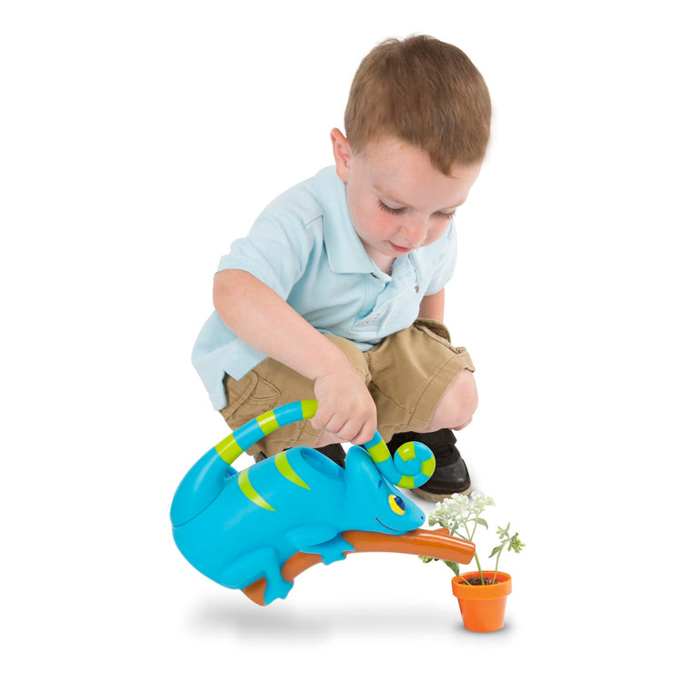 A child on white background with the Melissa & Doug Sunny Patch Camo Chameleon Watering Can With Tail Handle and Branch-Shaped Spout