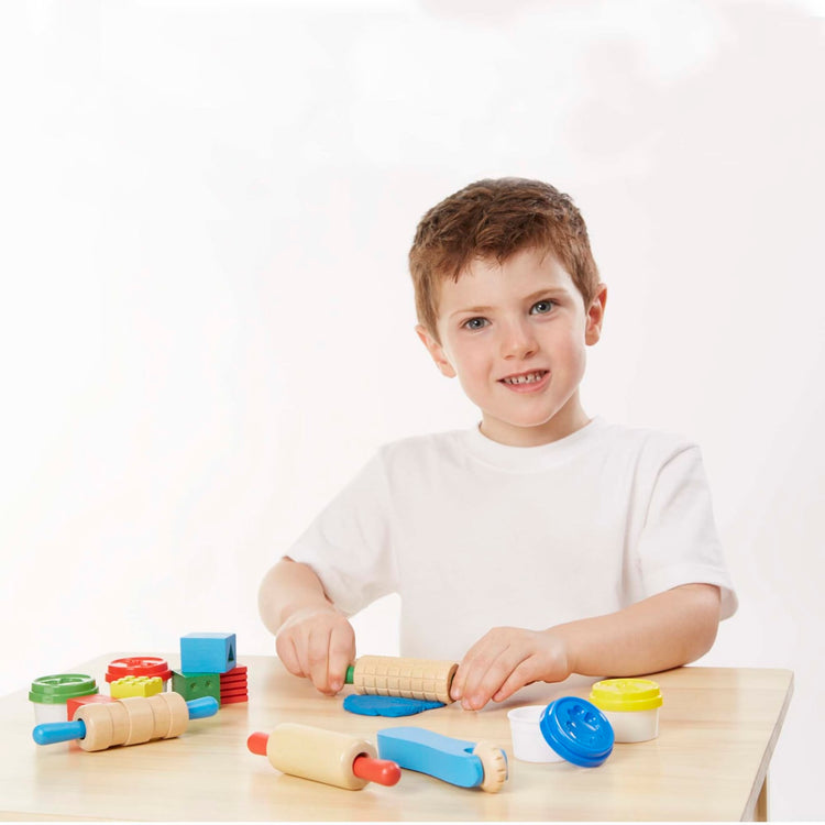 A child on white background with the Melissa & Doug Clay Play Activity Set - With Sculpting Tools and 8 Tubs of Modeling Dough