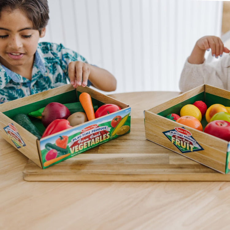 A kid playing with the Melissa & Doug Play-Time Produce Fruit (9 pcs) and Vegetables (7 pcs) Realistic Play Food