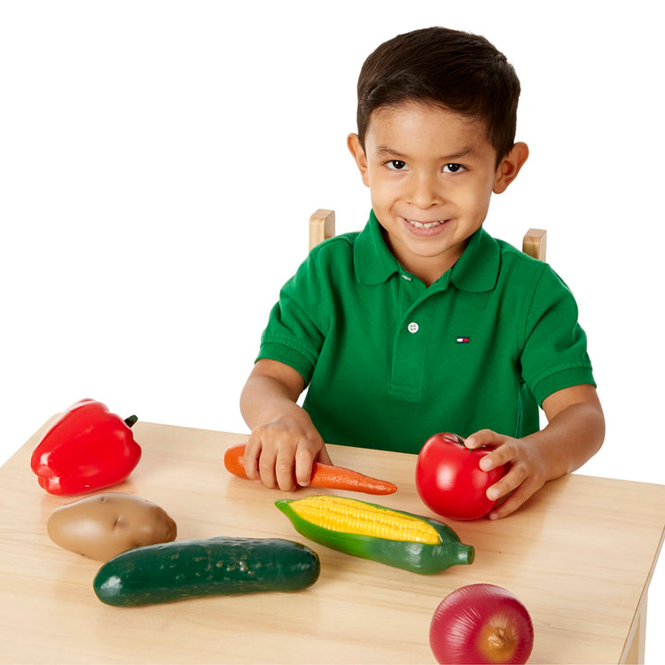 A child on white background with the Melissa & Doug Play-Time Produce Fruit (9 pcs) and Vegetables (7 pcs) Realistic Play Food
