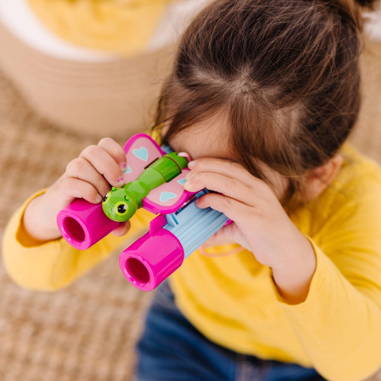A kid playing with the Melissa & Doug Sunny Patch Cutie Pie Butterfly Binoculars - Pretend Play Toy