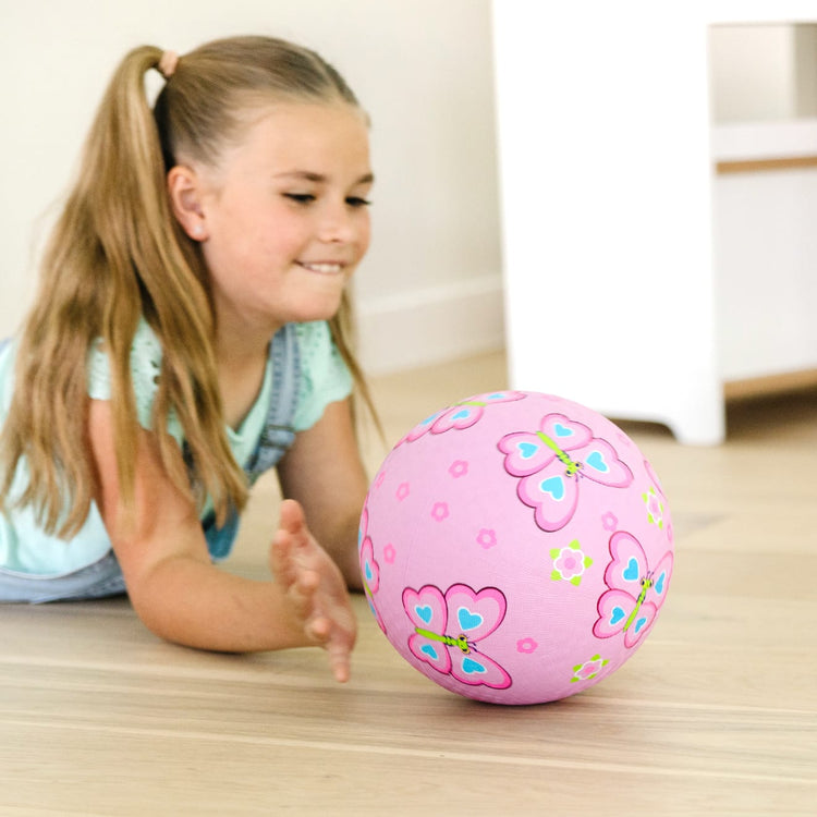 A kid playing with the Melissa & Doug Sunny Patch Cutie Pie Butterfly Classic Rubber Kickball