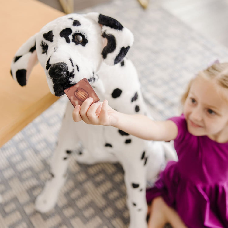 A kid playing with the Melissa & Doug Giant Dalmatian - Lifelike Stuffed Animal Dog (over 2 feet tall)