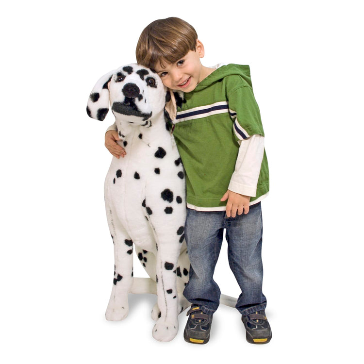 A child on white background with the Melissa & Doug Giant Dalmatian - Lifelike Stuffed Animal Dog (over 2 feet tall)