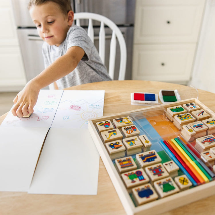 The front of the box for the Melissa & Doug Deluxe Wooden Stamp and Coloring Set – Vehicles (30 Stamps, 6 Markers, 2 Durable 2-Color Stamp Pads)