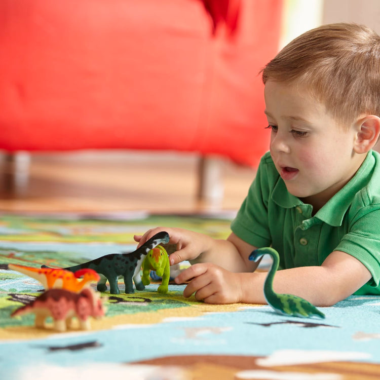A kid playing with the Melissa & Doug Dinosaur Party Play Set - 9 Collectible Miniature Dinosaurs in a Case