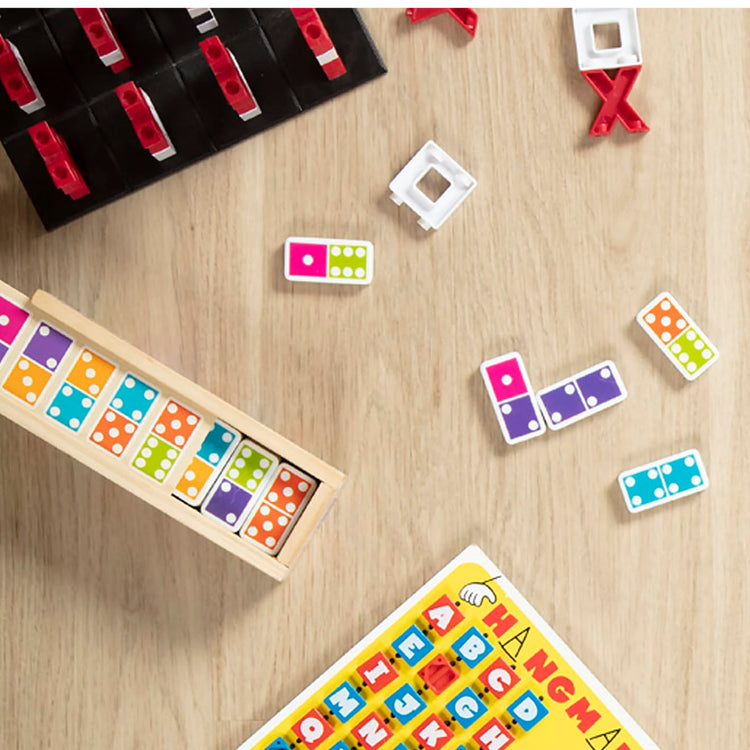 A kid playing with the Melissa & Doug Dominoes Tabletop Game with 28 Colorful Tiles in Wooden Storage Box