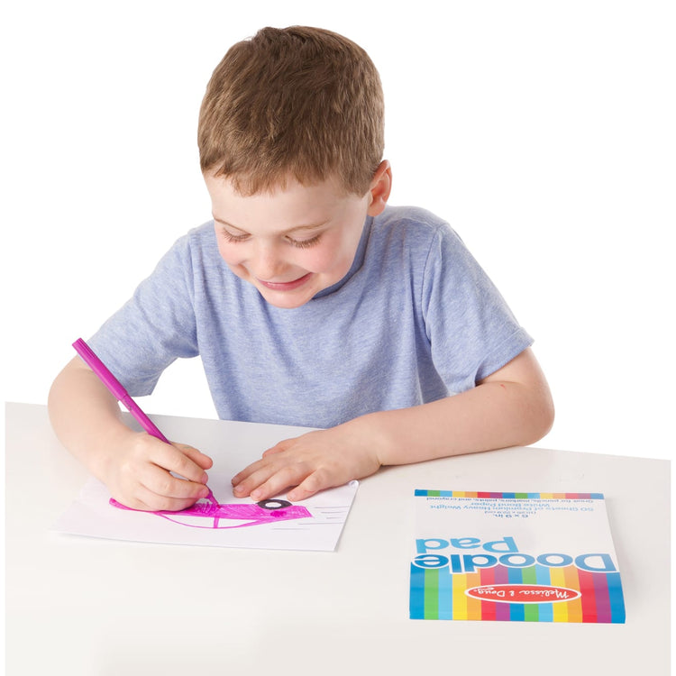 A child on white background with the Melissa & Doug Doodle Pad (6 x 9 inches) With 50 Sheets of White Bond Paper
