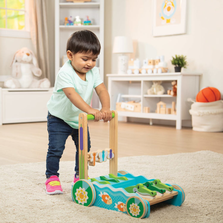 A kid playing with the Melissa & Doug First Play Chomp and Clack Alligator Wooden Push Toy and Activity Walker