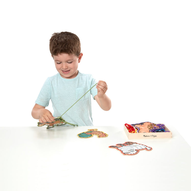 A child on white background with the Melissa & Doug Lace and Trace Activity Set: 5 Wooden Panels and 5 Matching Laces - Farm