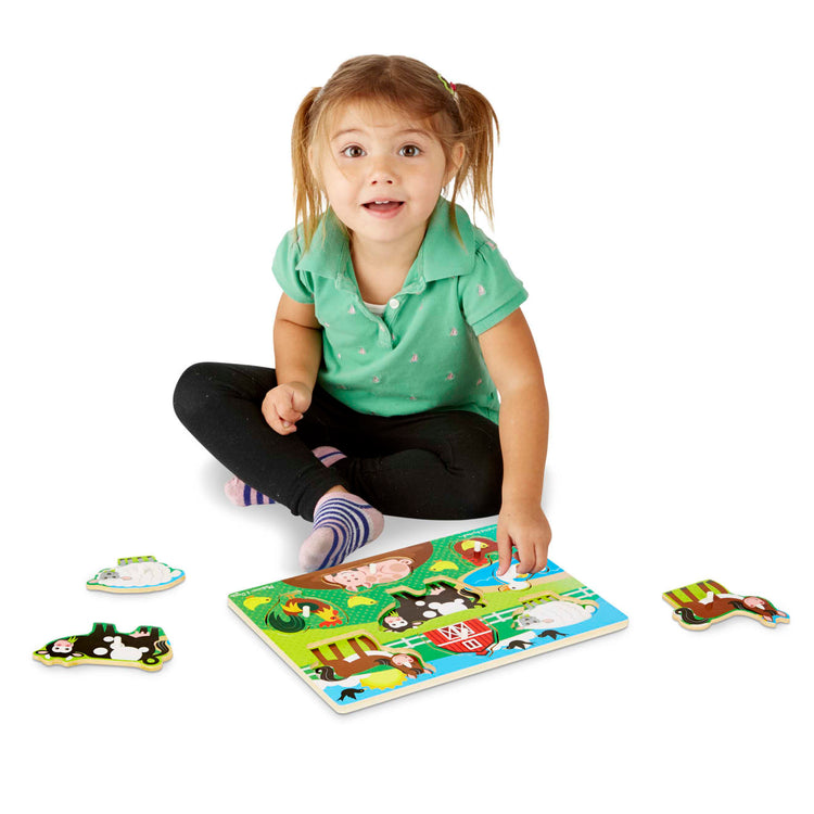A child on white background with the Melissa & Doug Farm Wooden Peg Puzzle (8 pcs)