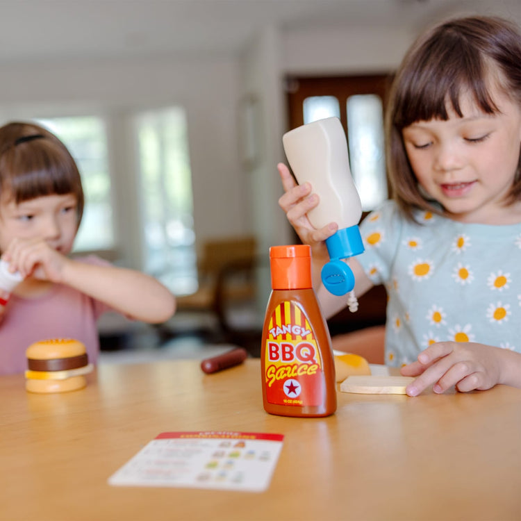 A kid playing with the Melissa & Doug 5-Piece Favorite Condiments Play Food Set