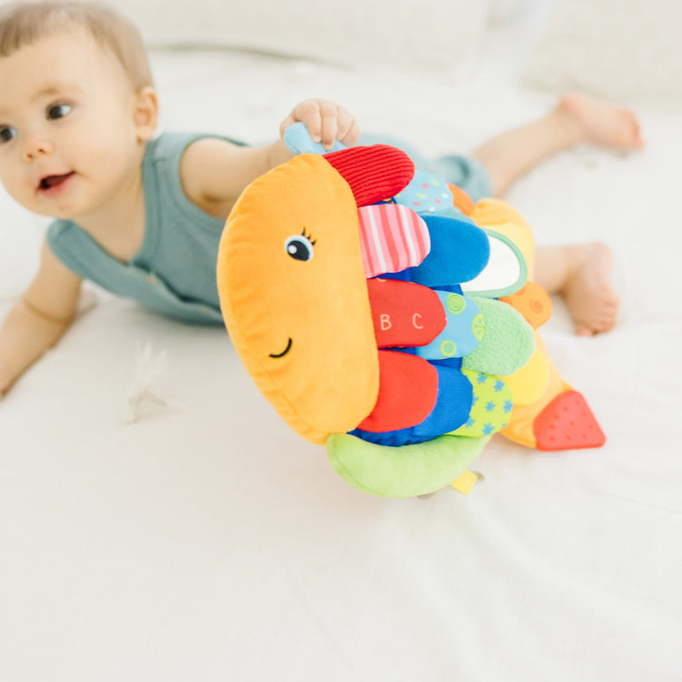 A kid playing with the Melissa & Doug Flip Fish Soft Baby Toy