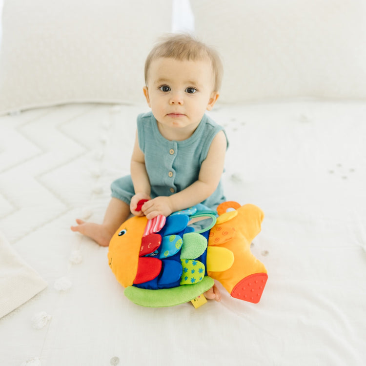 A kid playing with the Melissa & Doug Flip Fish Soft Baby Toy