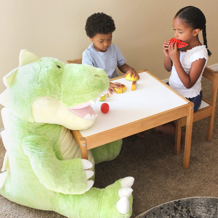 A kid playing with the Melissa & Doug Gentle Jumbos Dinosaur Giant Stuffed Plush Animal (Sits Nearly 3 Feet Tall)