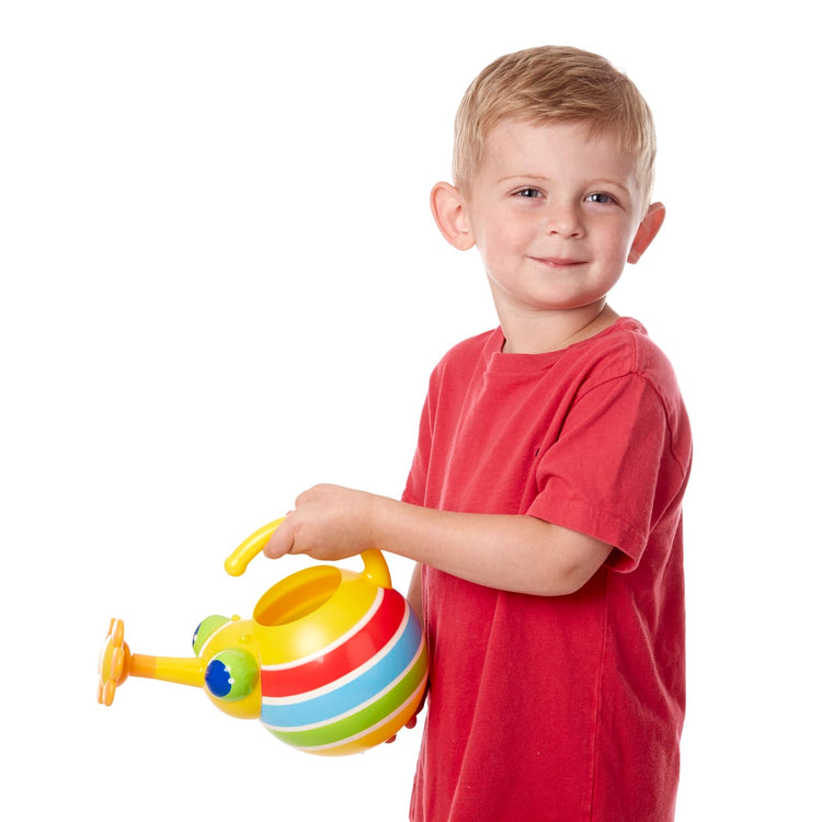 A child on white background with the Melissa & Doug Sunny Patch Giddy Buggy Watering Can With Flower-Shaped Spout