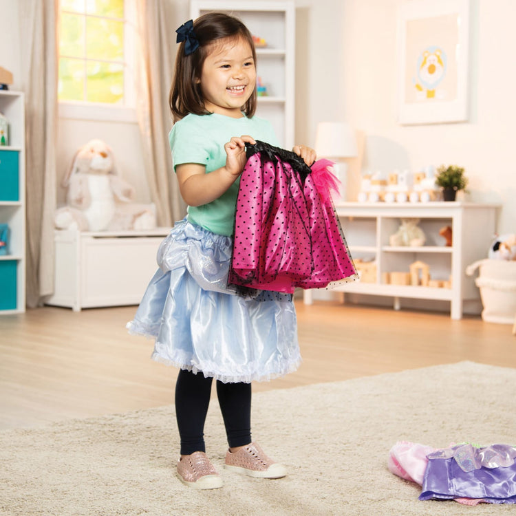 A kid playing with the Melissa & Doug Role Play Collection - Goodie Tutus! Dress-Up Skirts Set (4 Costume Skirts)