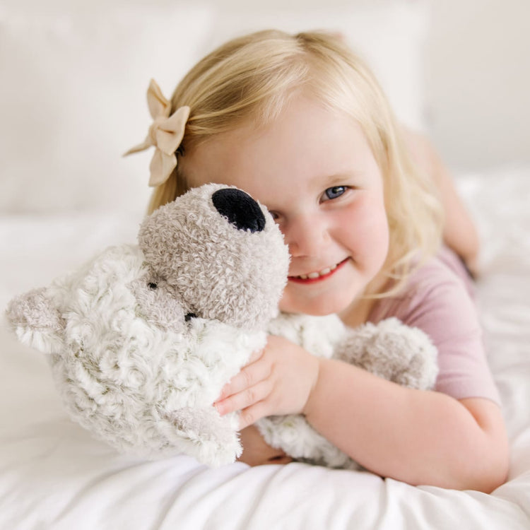 A kid playing with the Melissa & Doug Greyson Bear Stuffed Animal