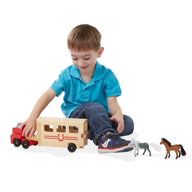 A child on white background with the Melissa & Doug Horse Carrier Wooden Vehicle Play Set With 2 Flocked Horses and Pull-Down Ramp