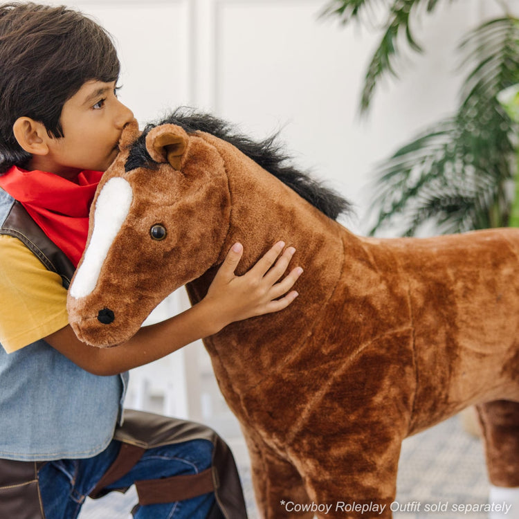 A kid playing with the Melissa & Doug Giant Horse - Lifelike Stuffed Animal (nearly 3 feet tall)