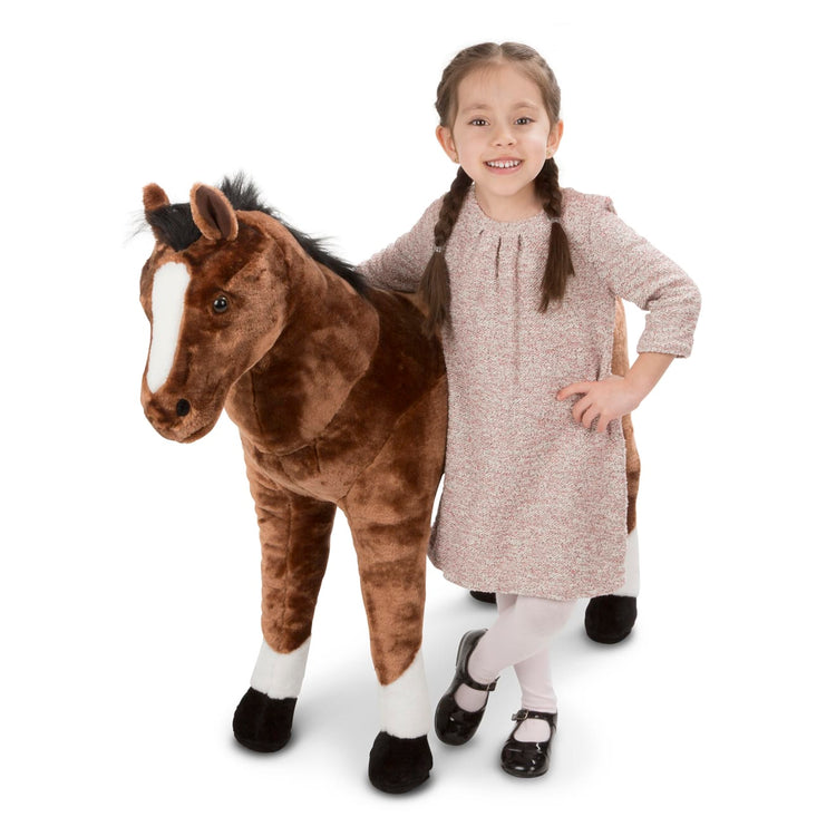 A child on white background with the Melissa & Doug Giant Horse - Lifelike Stuffed Animal (nearly 3 feet tall)