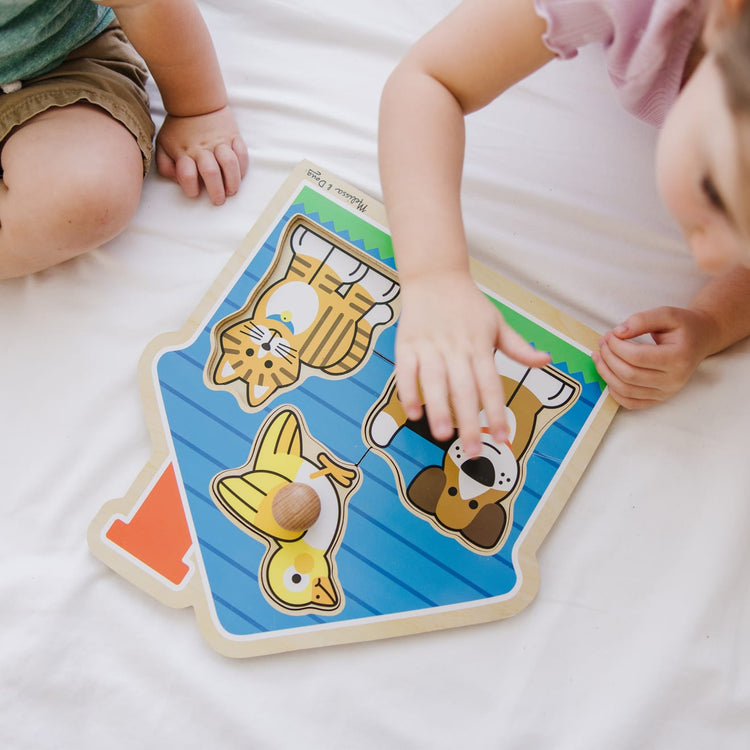 A kid playing with the Melissa & Doug Pets Jumbo Knob Wooden Puzzle