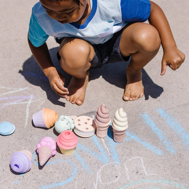 A kid playing with the Melissa & Doug Sweet Treats Chalk Play Set (12 Pieces)