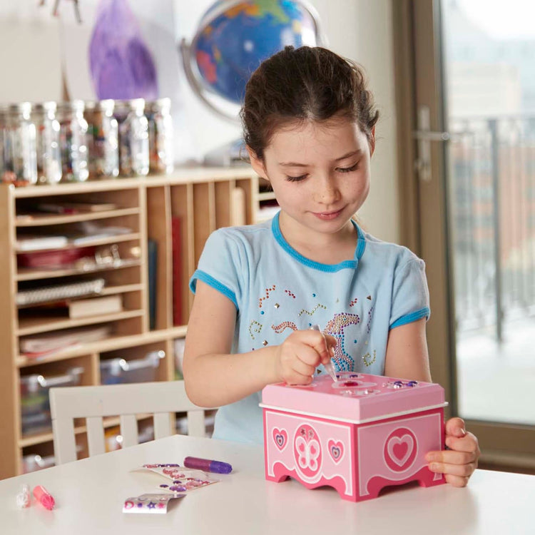 A kid playing with the Melissa & Doug Created by Me! Jewelry Box Wooden Craft Kit