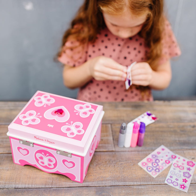 A kid playing with the Melissa & Doug Created by Me! Jewelry Box Wooden Craft Kit