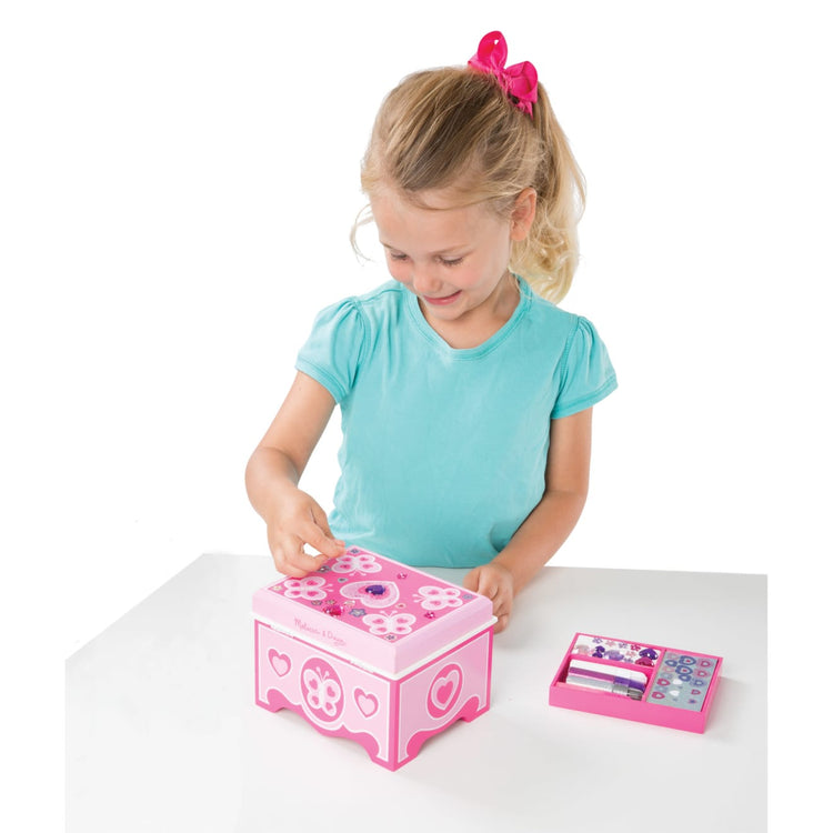 A child on white background with the Melissa & Doug Created by Me! Jewelry Box Wooden Craft Kit
