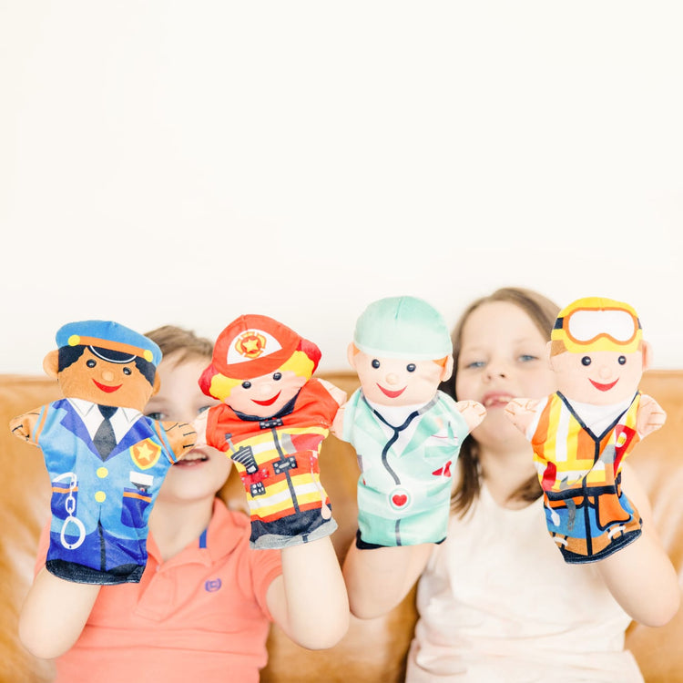 A kid playing with the Melissa & Doug Jolly Helpers Hand Puppets (Set of 4) - Construction Worker, Doctor, Police Officer, and Firefighter