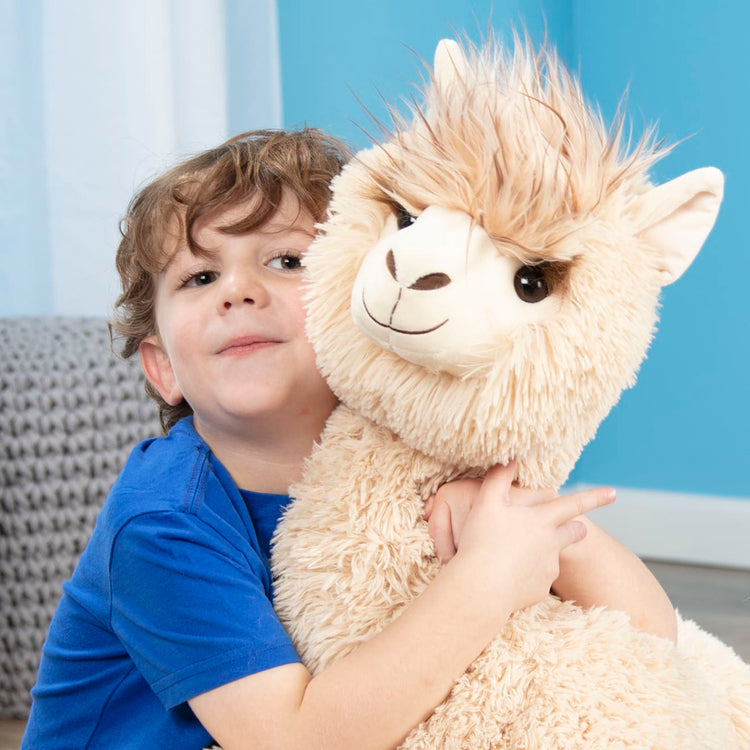 A kid playing with the Melissa & Doug Jumbo Llama Stuffed Plush Animal (26 Inches Tall)