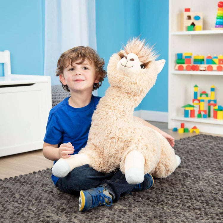 A kid playing with the Melissa & Doug Jumbo Llama Stuffed Plush Animal (26 Inches Tall)
