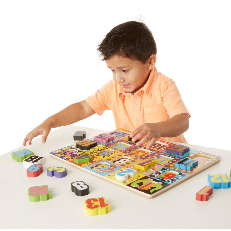 A child on white background with the Melissa & Doug Jumbo Numbers Wooden Chunky Puzzle (20 pcs)