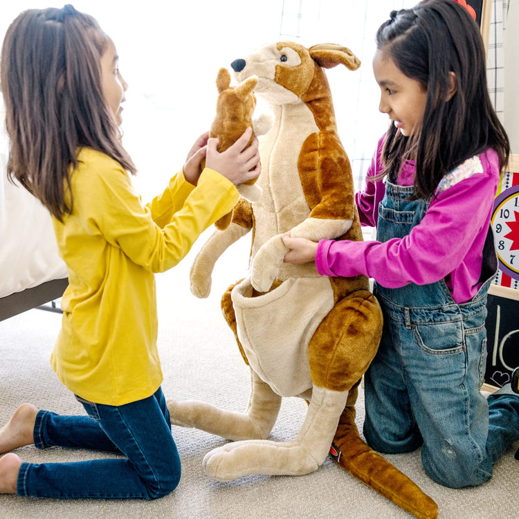 A kid playing with the Melissa & Doug Giant Kangaroo and Baby Joey in Pouch - Lifelike Stuffed Animal (nearly 3 feet tall)